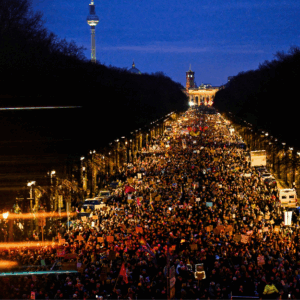 Large crowd in Germany protesting against far-right politics with banners and signs.