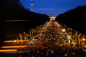 Large crowd in Germany protesting against far-right politics with banners and signs.